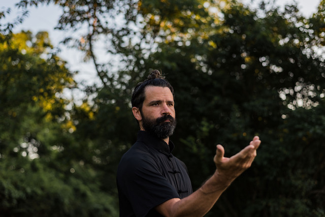 Matt Branstetter in front of trees doing taiji