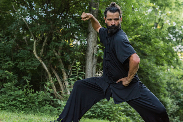matt branstetter in a taiji form in front of a wooded area